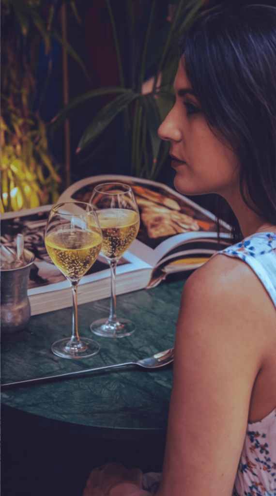 Jeune femme élégante dégustant du champagne dans un restaurant insolite à Paris 1er, ambiance feutrée et atmosphère intime au cœur du centre de Paris.