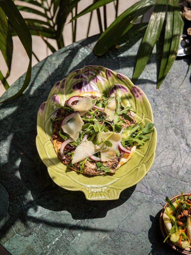 Pizzetta à la truffe servie chez Inavoué, restaurant original à Paris 1. Pâte croustillante, fromage fondant, roquette fraîche et copeaux de parmesan, au cœur du 1er arrondissement près de la place Vendôme et du Marché Saint-Honoré.